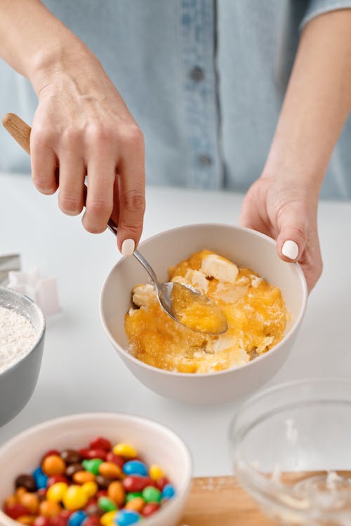 Person Mixing Yellow Eggs in a Bowl