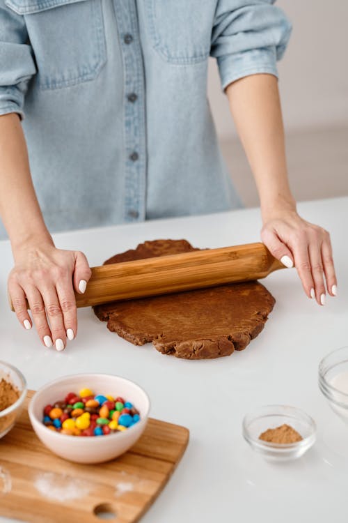 Person Flattening a Dough With Rolling Pin