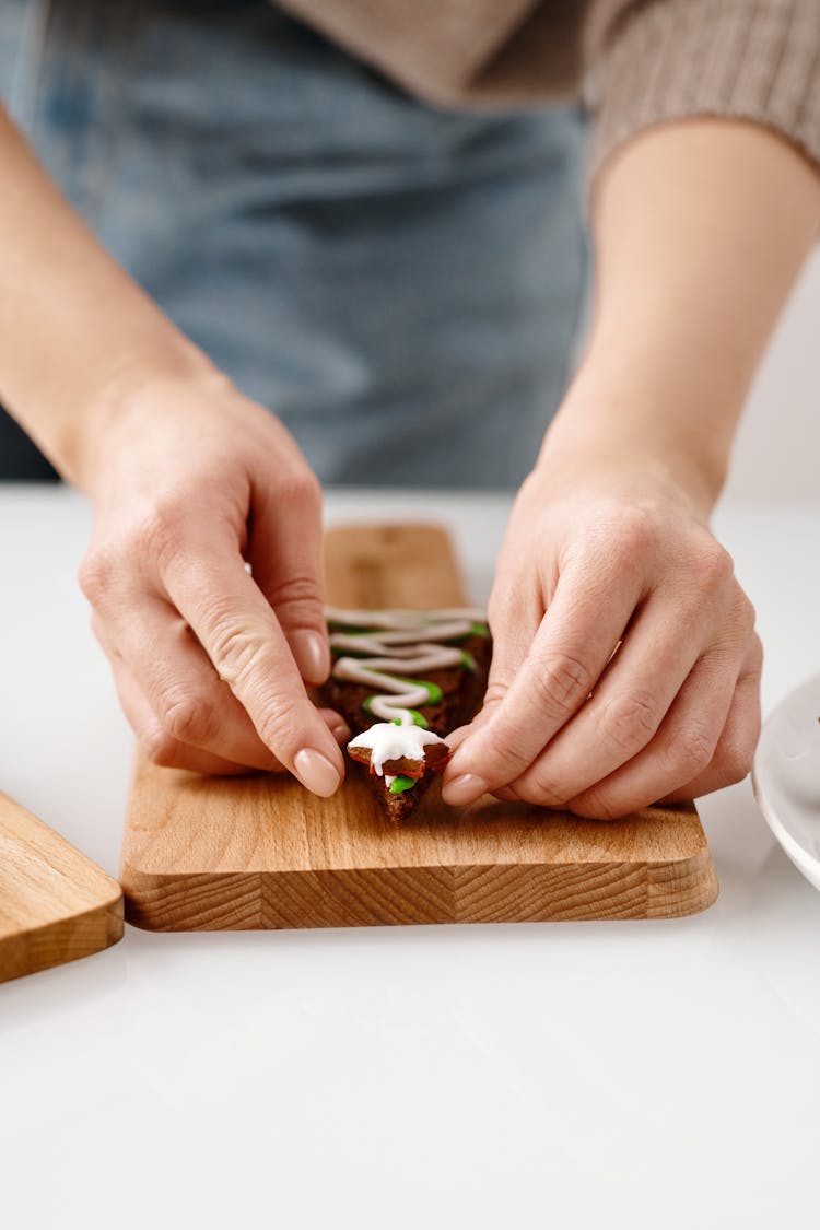 Person Decorating A Brown Cookie