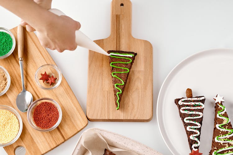 Person Decorating A Brown Cookie