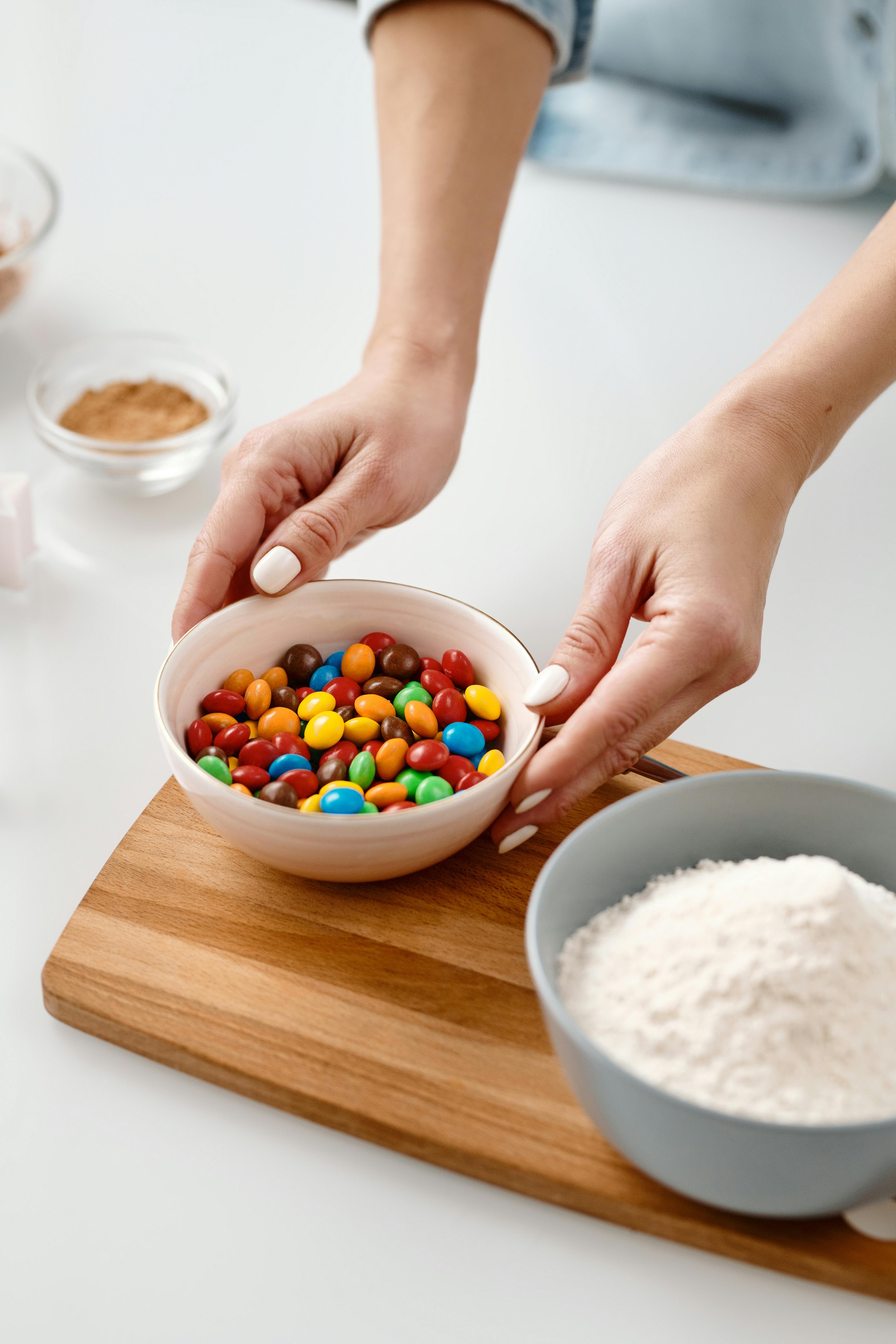 person holding a ceramic bowl with chocolate candies