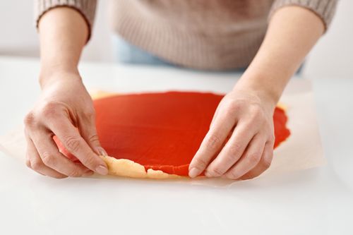 Free Close-up of hands preparing dough with wax paper for a homemade pastry. Stock Photo