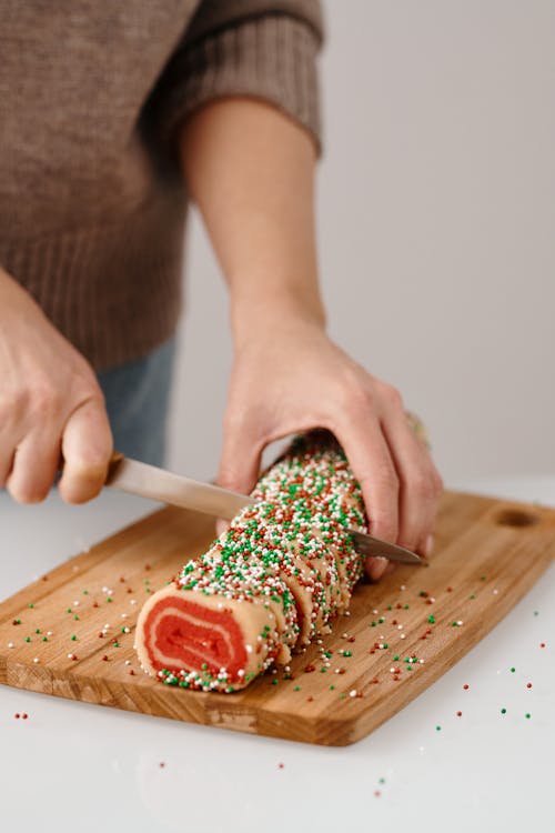 Person Holding Brown Wooden Chopping Board With Red and White Sauce