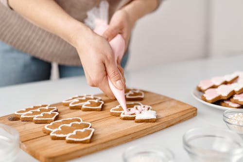 Free Person Decorating a Christmas Tree Shaped Cookies Stock Photo