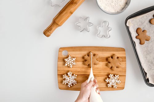 Personne Décorant Un Biscuits En Forme De Flocons De Neige