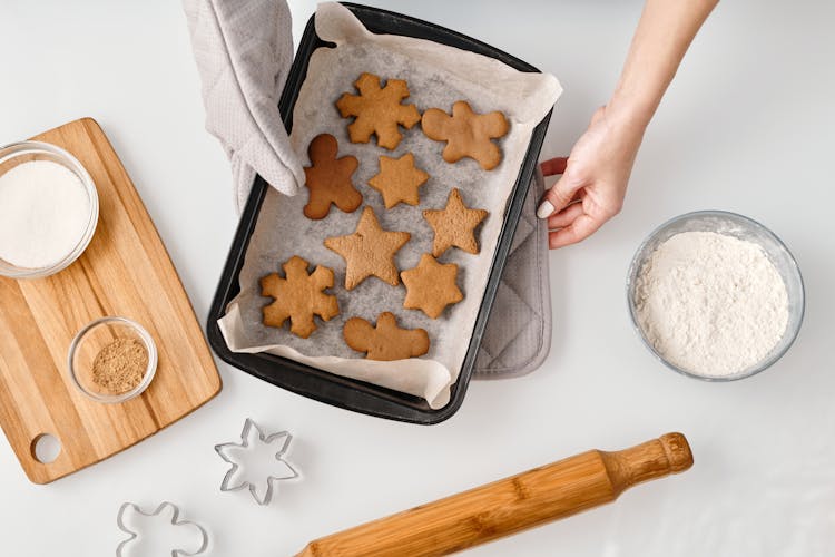 Person Holding A Tray With Different Shapes Of Brown Cookies