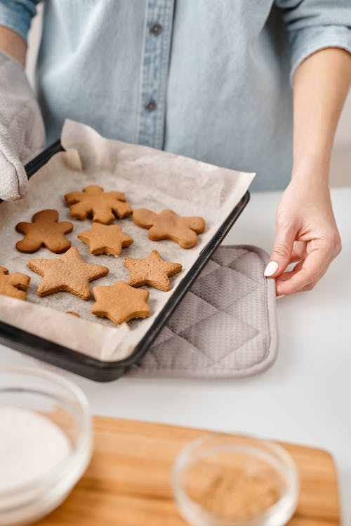 Person Holding a Tray With Different Shapes of Brown Cookies