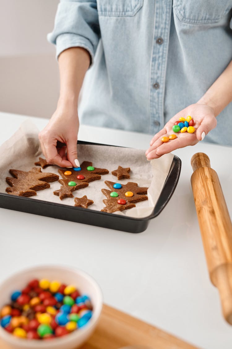 Person Decorating A Christmas Tree Shaped Cookies