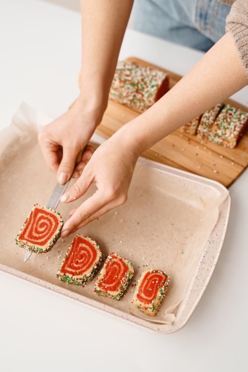 Free Sliced spiral cookies on a baking tray with colorful sprinkles, conveying festive vibes. Stock Photo
