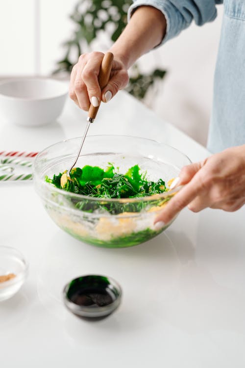 Free Person Mixing a Vegetable Salad in a Bowl Stock Photo