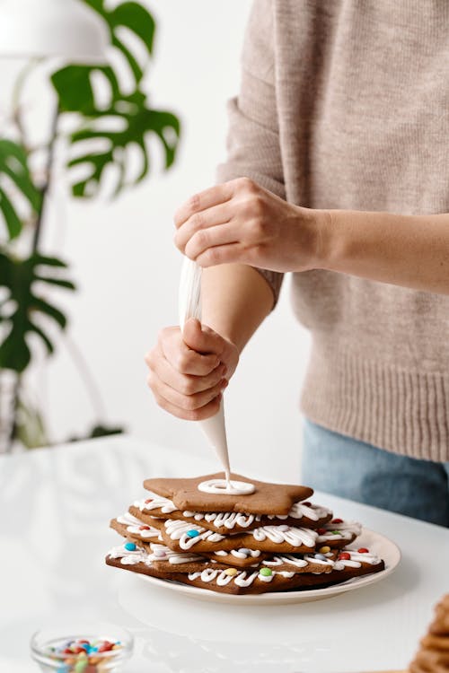 Free A Person Putting Whipped Cream on Top of the Cookies Stock Photo