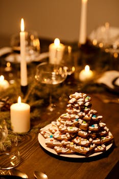 A cozy Christmas dinner setup with decorated cookies and candlelight ambiance.