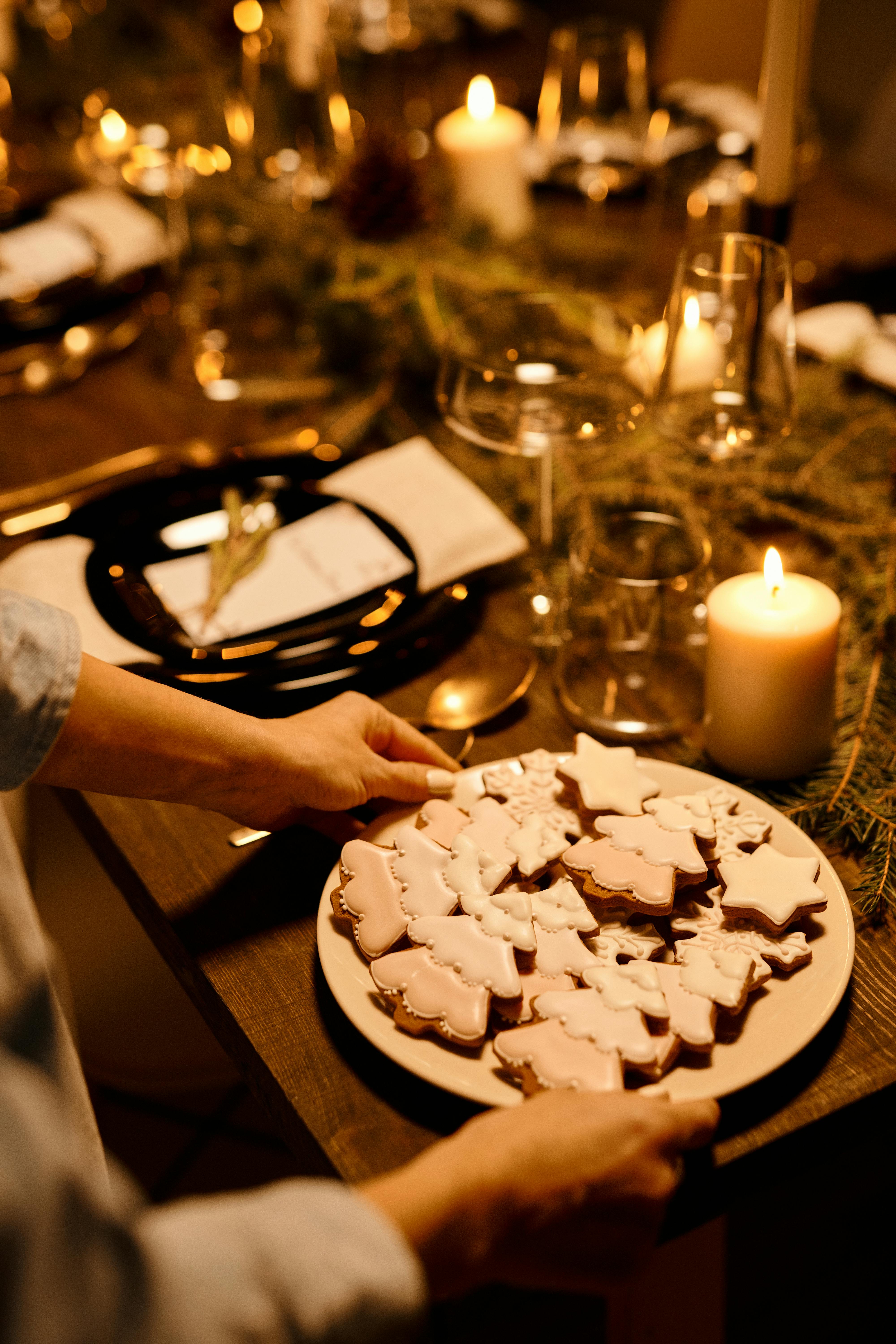 person serving a plate of christmas shaped cookies