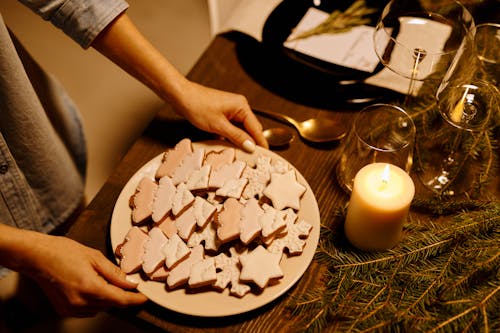 Persona Che Serve Un Piatto Di Biscotti A Forma Di Albero Di Natale