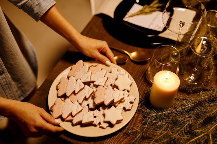 Person Serving A Platter Of Christmas Tree Shaped Cookies