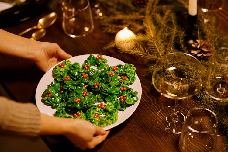 Person Serving A Vegetable Salad On A Plate