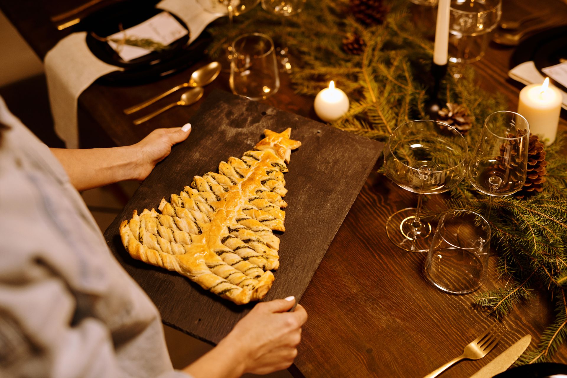 Person Serving a Freshly Baked Bread on a Wooden Tray