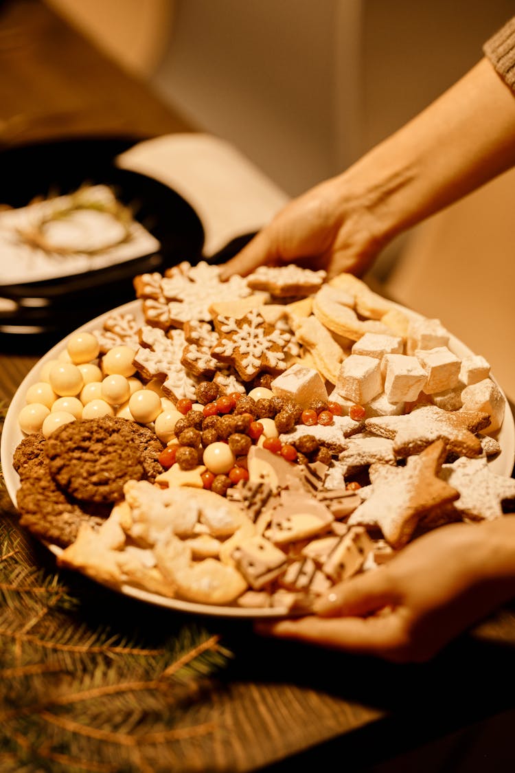 Person Holding A Platter Of Homemade Biscuits