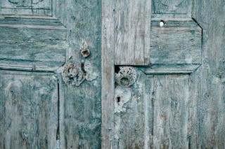 Shabby wooden blue doors with rusted locks