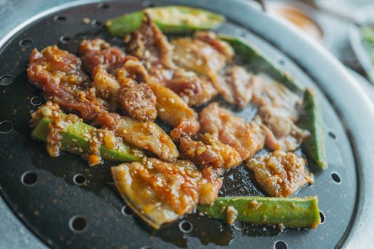 Delicious grilled meat and okra sizzling on a barbecue grill, perfect for dinner.