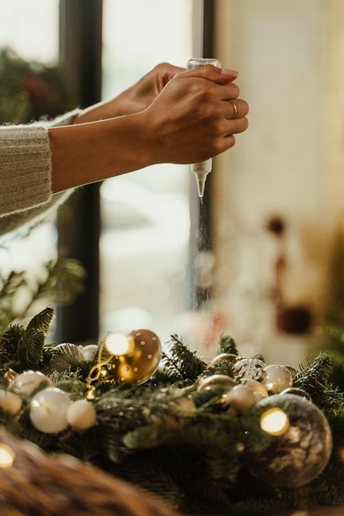 Free Person in Knit Sweater Using a Glue for Decorating a Wreath Stock Photo