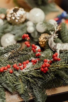 A close-up of a holiday wreath with red berries, ornaments, and a reindeer decoration.