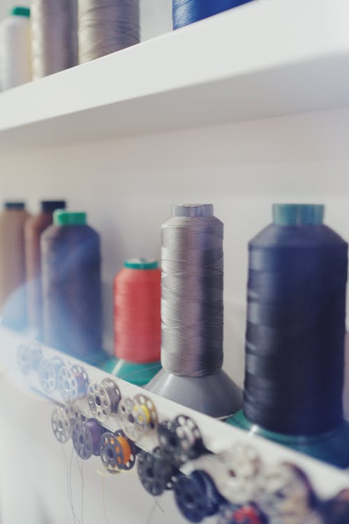 Spool of Threads and Hanging Metal Bobbins on Shelves
