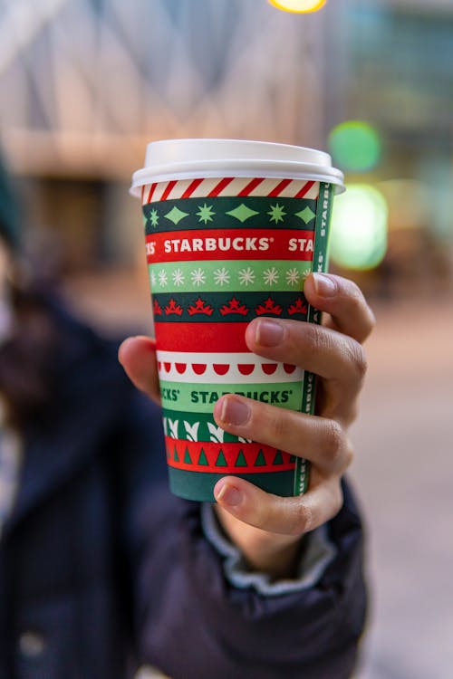 Free A Hand Holding a Colorful Starbucks Paper Cup Stock Photo