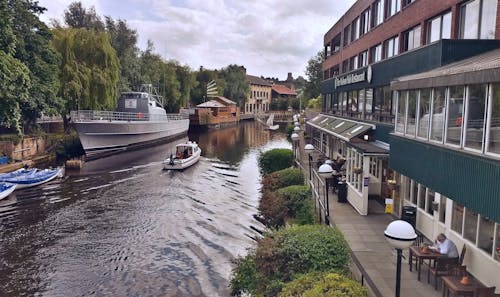 White Boat on River Near a Restaurant