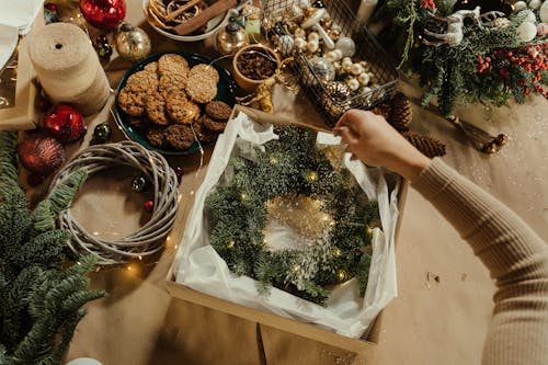 A Person Putting the Hanging Wreath on a Box