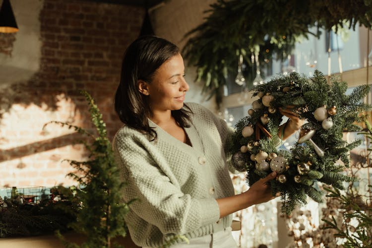 A Woman Holding A Christmas Wreath