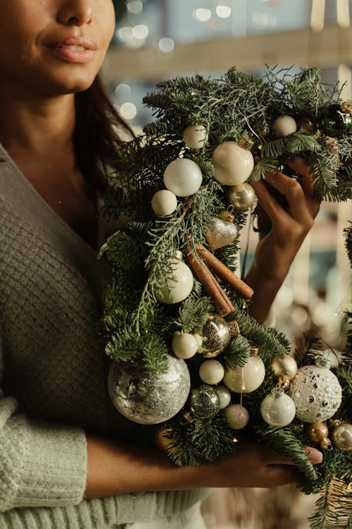 Woman Holding a Christmas Wreath with Baubles 