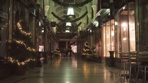 Free Christmas decorations adorn an indoor shopping hall with elegant festive lights and holiday greenery. Stock Photo