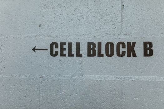 Arrow pointing to Cell Block B on a textured concrete wall.
