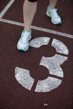 Close-up of a runner's foot on a track near lane three marking. — photo by Volker Meyer