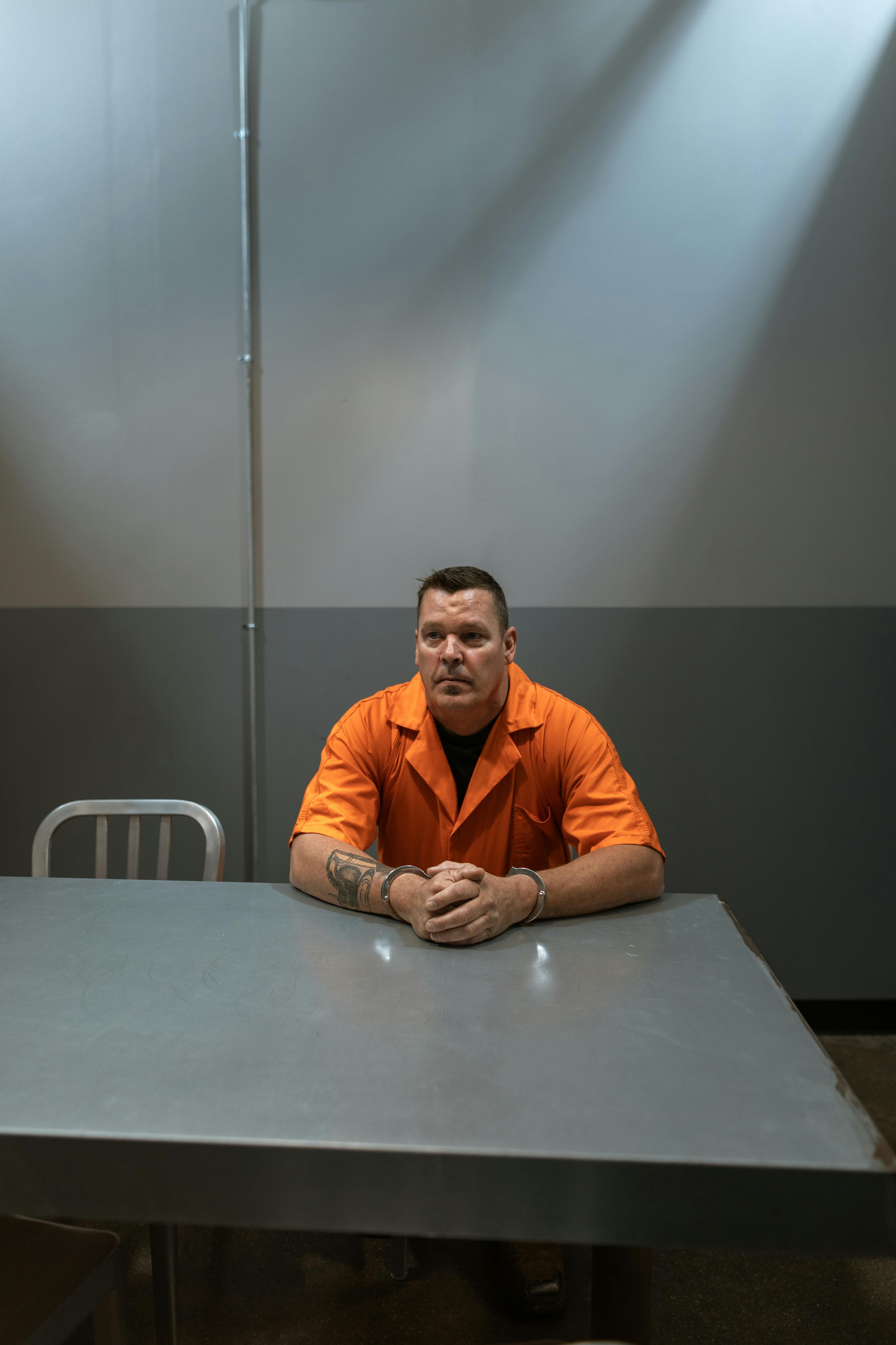 man in orange shirt sitting on chair