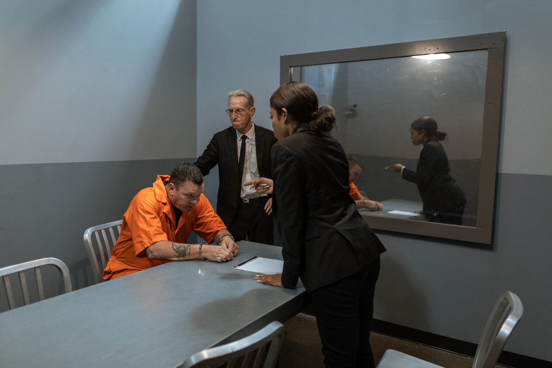 운전자보험 개정 핵심, 변호사비·공탁금·6주 미만 정리 3 A tense interrogation scene showing a prisoner, lawyer, and detective in a police station room.