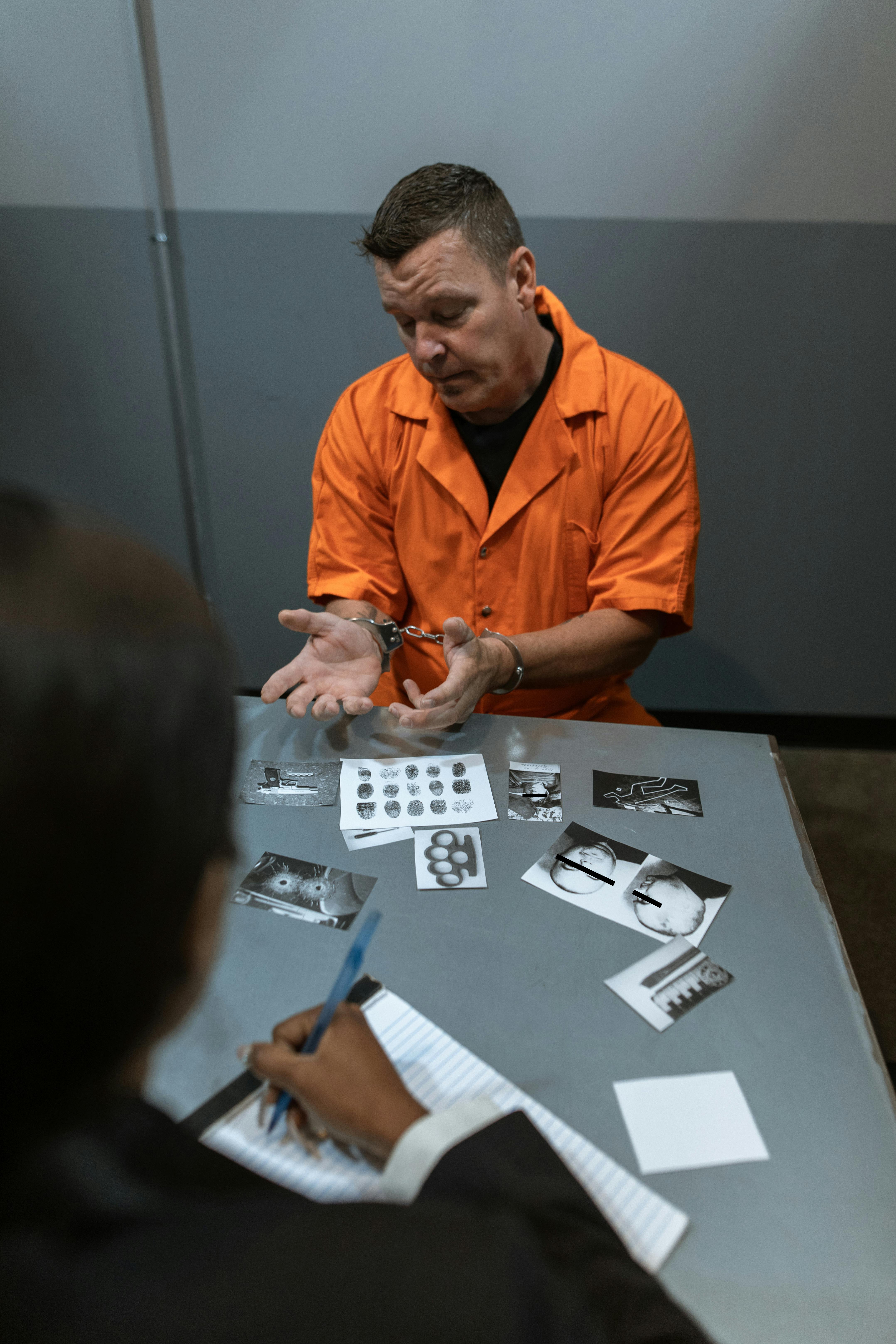 man in orange button up shirt holding blue pen