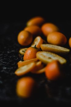 Artistic photo of sliced kumquats with moody lighting and focus variation.
