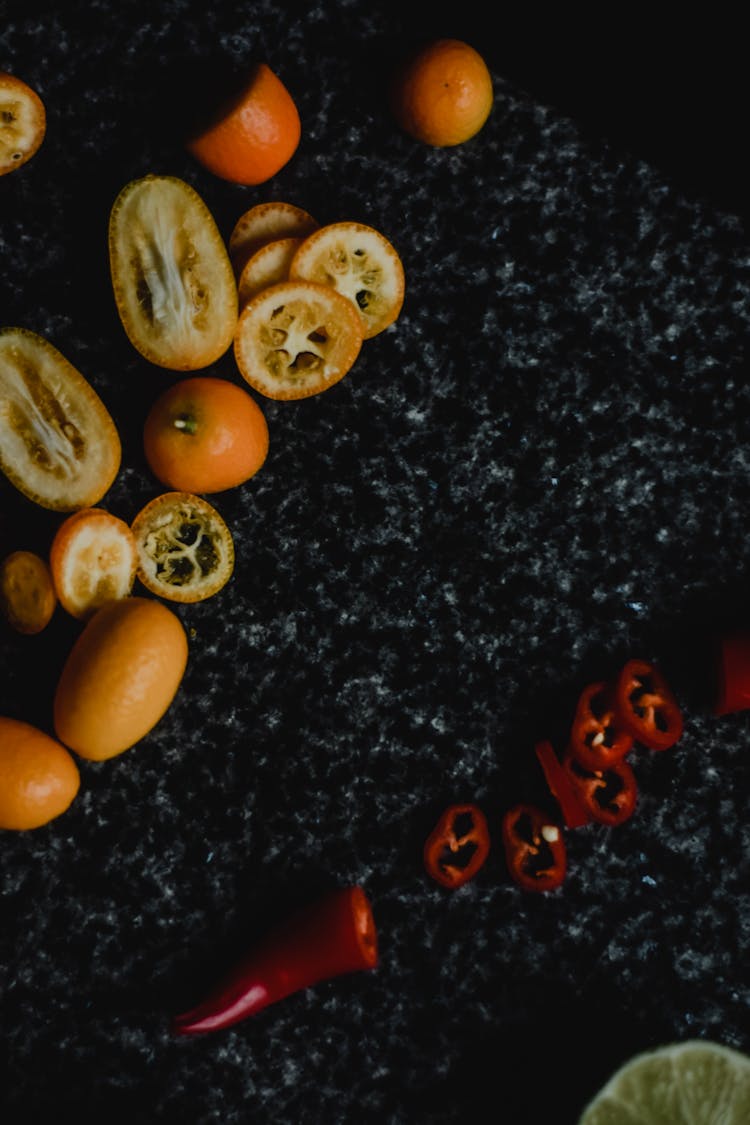 Sliced Kumquat On A Black And Gray Marble Surface