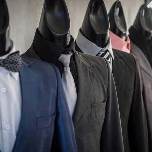 Mannequins dressed in formal men's outfits inside the store