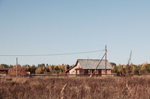 Free Exterior of shabby wooden cottage located on remote countryside area under blue sky in autumn day Stock Photo