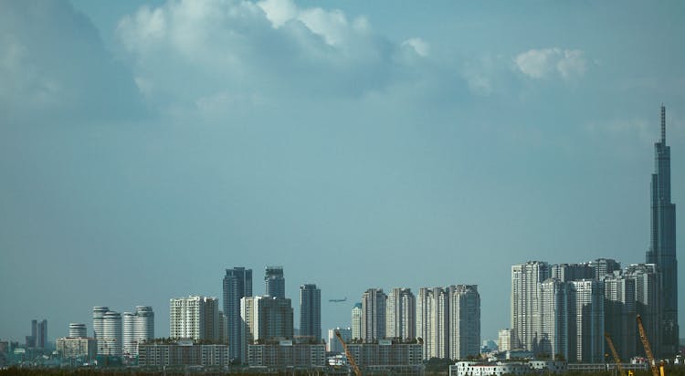 City Skyline And A Distant Airplane