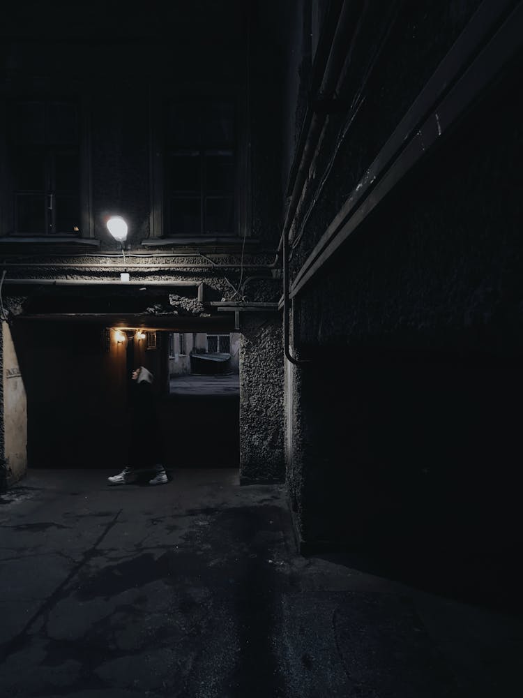 A Person Walking In A Dark Alley