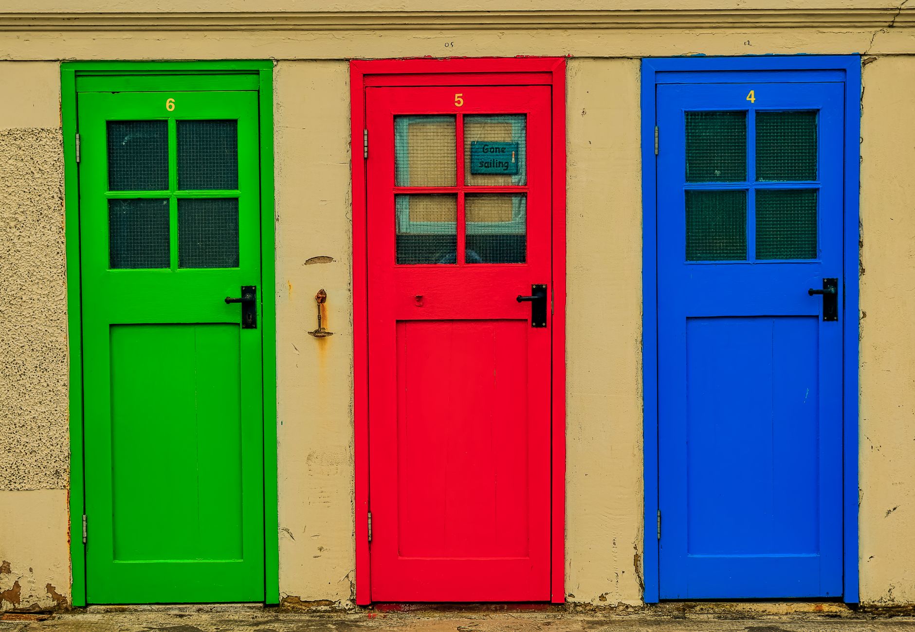Brightly colored green, red, and blue doors in North Berwick create a striking visual contrast.