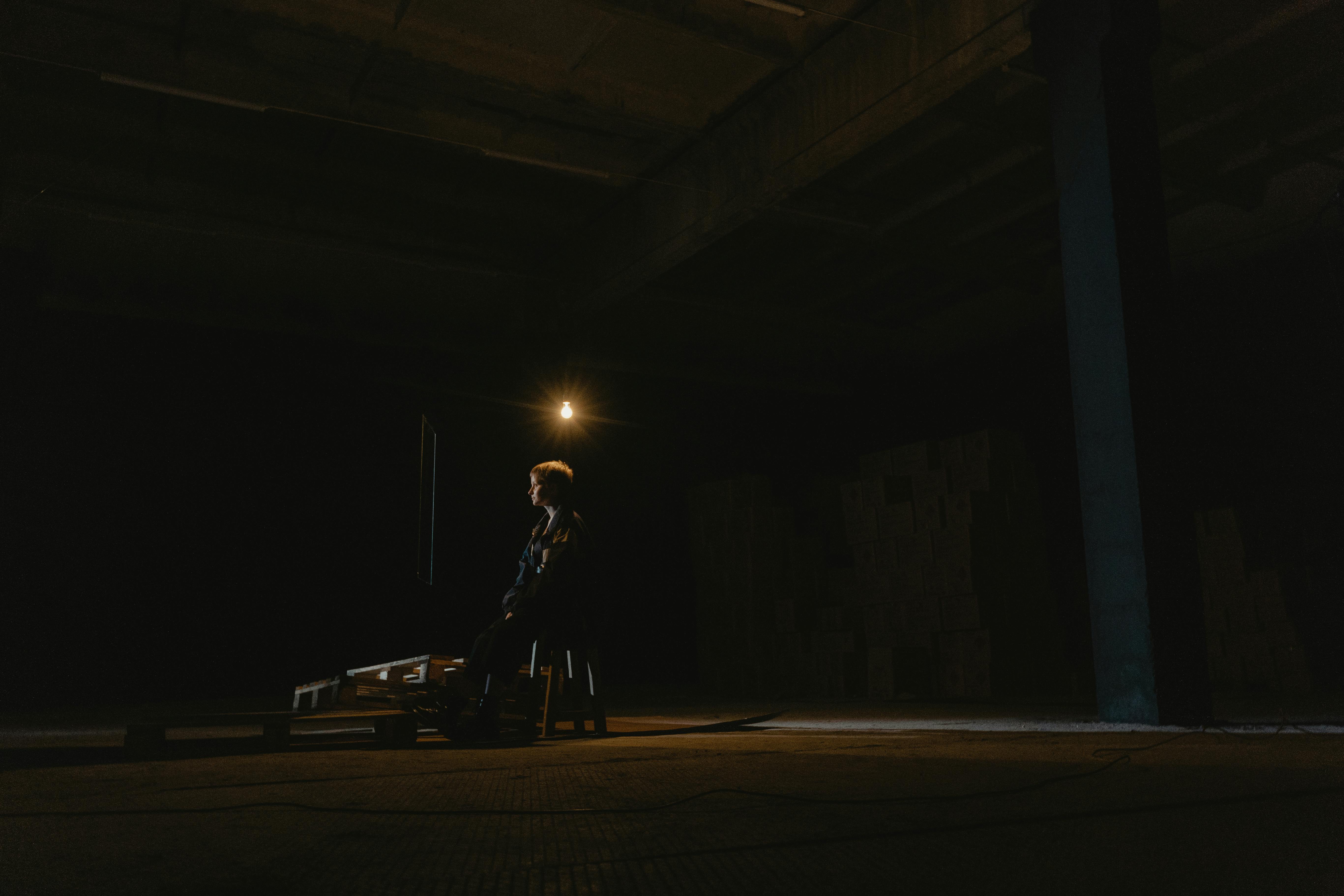 man in black jacket standing on road during night time