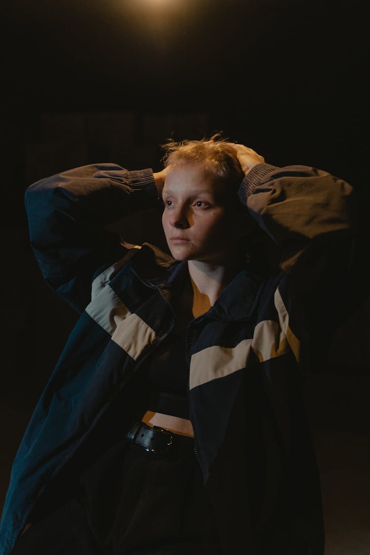 Woman In Black And Brown Jacket With Hands On Head