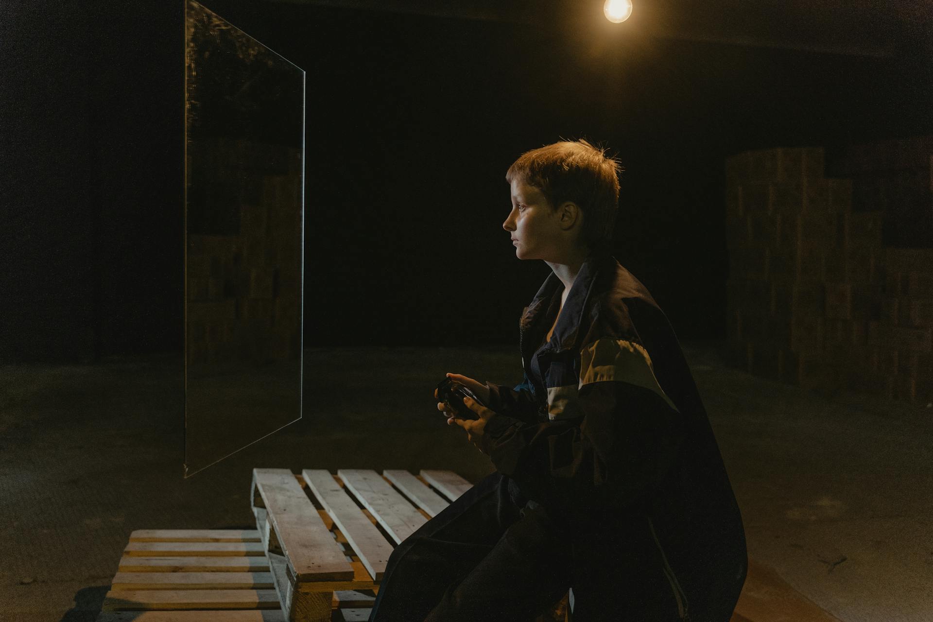 A Woman Wearing Jacket Looking at the Mirror Near the Wood Pallet