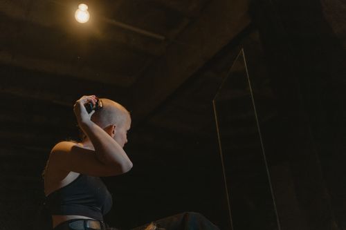 Free A woman shaves her head in a dimly lit room, reflecting empowerment and change. Stock Photo