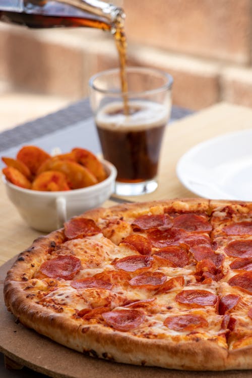 Pepperoni Pizza Beside the Glass of Drink